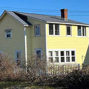 Large two-story residential home with yellow siding