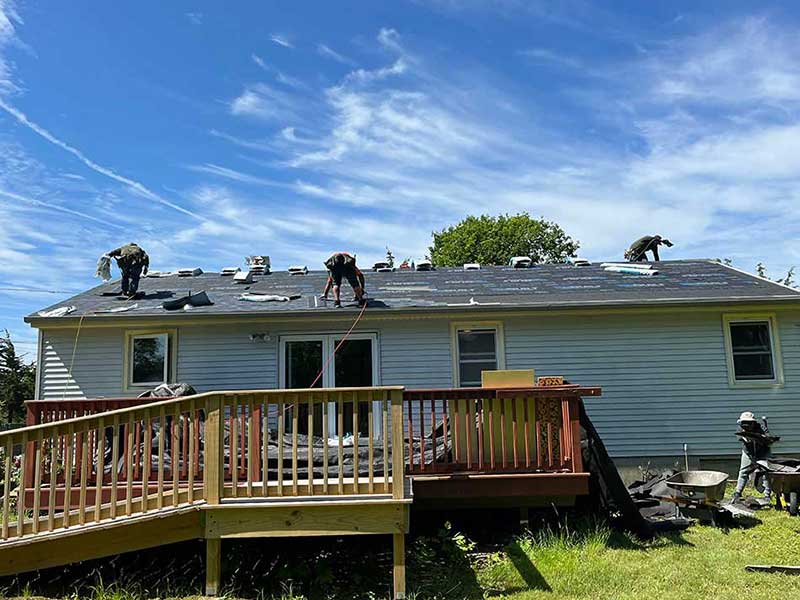 South County Exteriors workers on a small, one-story home getting the roof ready to have new shingles installed on it